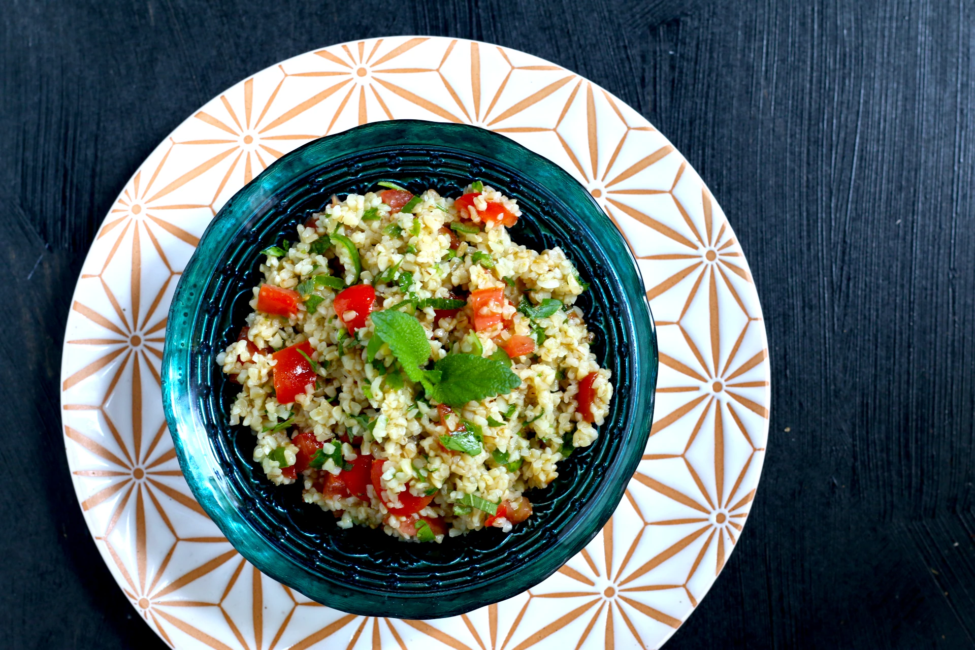 Bulgur-Salt mit Tomaten und Petersilie angerichtet in einer Schale.