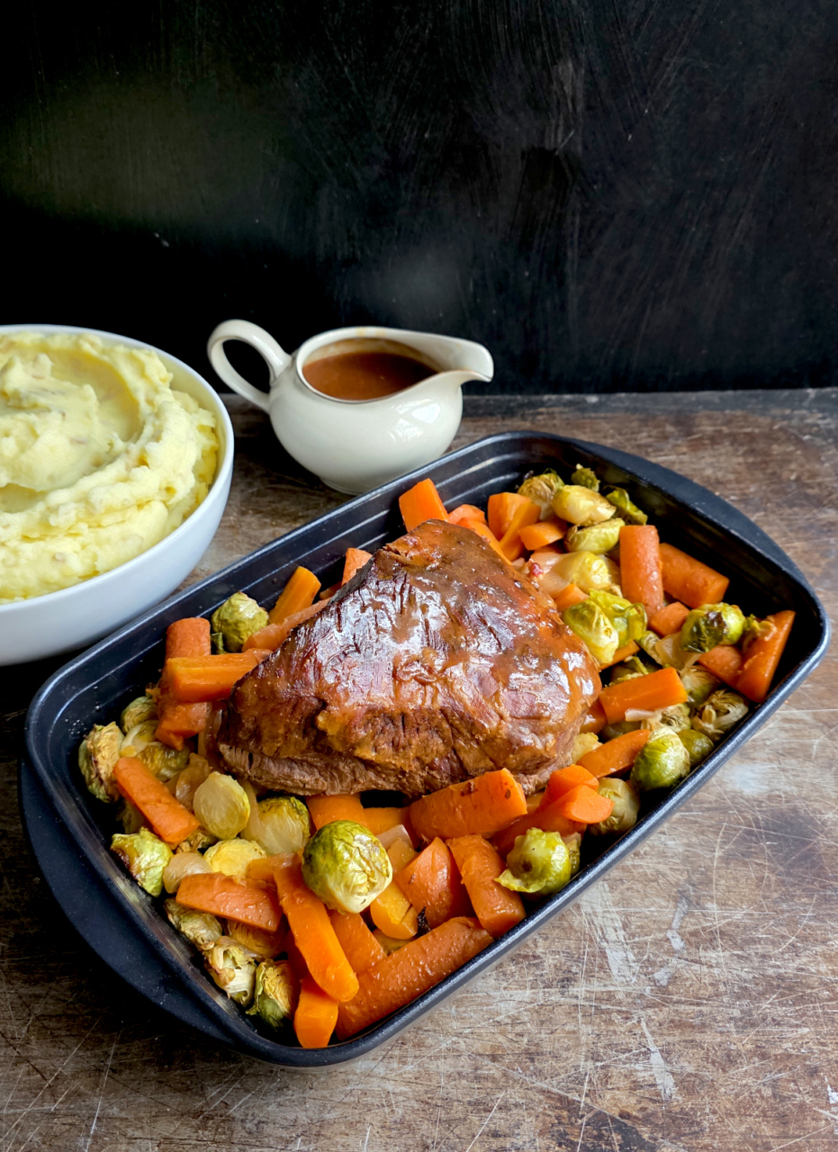 Geschmorrter Rindsschulterbraten aus dem Backofen mit Karotten und Rosenkohl.